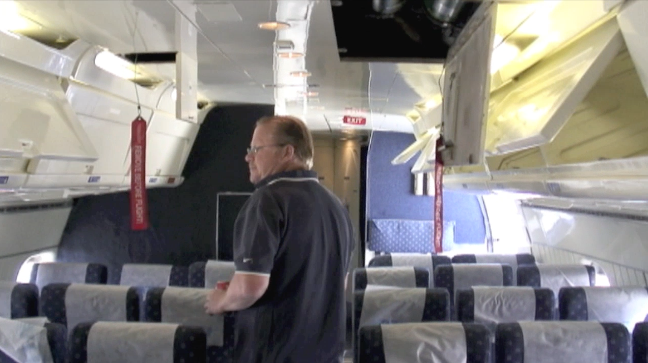 Passenger cabin with ATI maintenance engineer Robert Dobler during a maintenance inspection of ATI DC-8-62 N799AL at McClellan Airport on May 10, 2013. This is a screenshot from the 9 episode mini series "DC-8 Farewell" that streams on the JetFlix TV streaming service for aviation super fans.